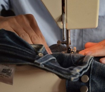 Feed the jeans and guide it through evenly!