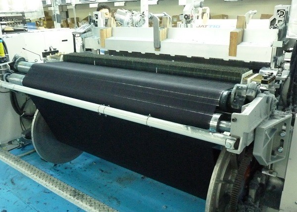 A projectile loom.  Notice the width of the denim being woven.