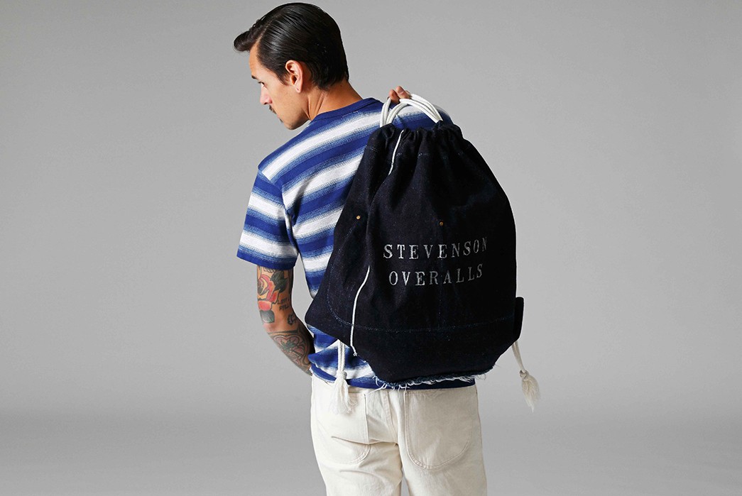 Stevenson-Overall-Co.-Releases-Their-Weekend-Warrior-Lookbook-blue-and-white-shirt-and-white-pants-with-bag