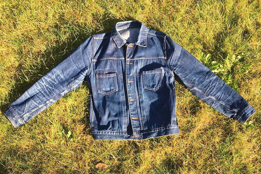 fade-of-the-day-a-p-c-work-jean-jacket-1-5-years-1-wash-2-soaks-front-on-grass