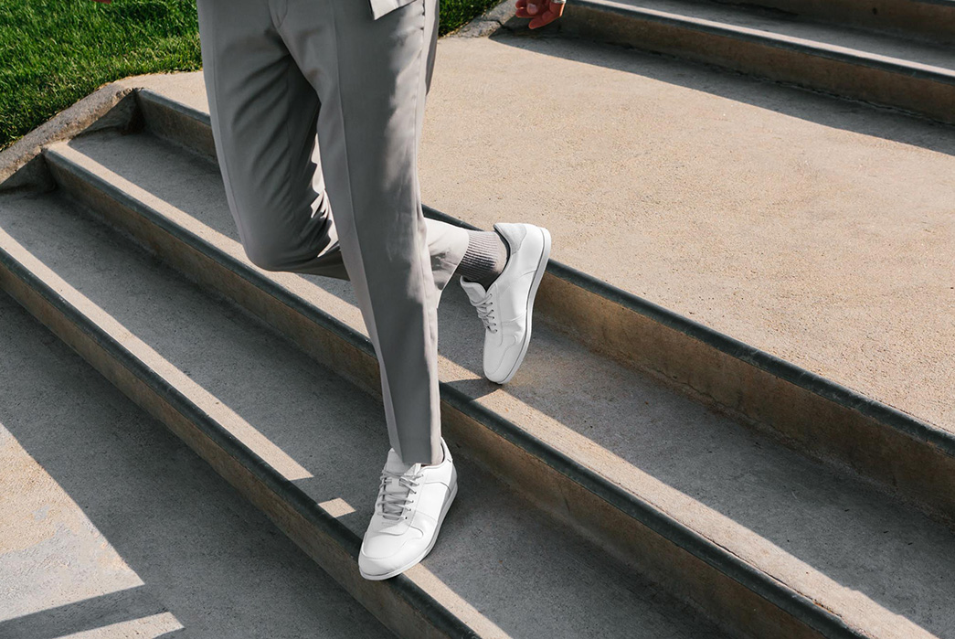 Standard-Fair's-American-Made-Resoleable-Sneakers-Go-Black-and-White-male-in-grey-walking-in-white-on-stairs-one-image