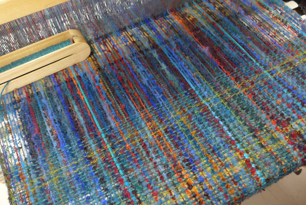 All-About-Boucle---Looping-In-With-The-Curliest-Cloth-Boucle-yarn-being-woven-into-fabric.-Image-via-Twisp-of-Fate.