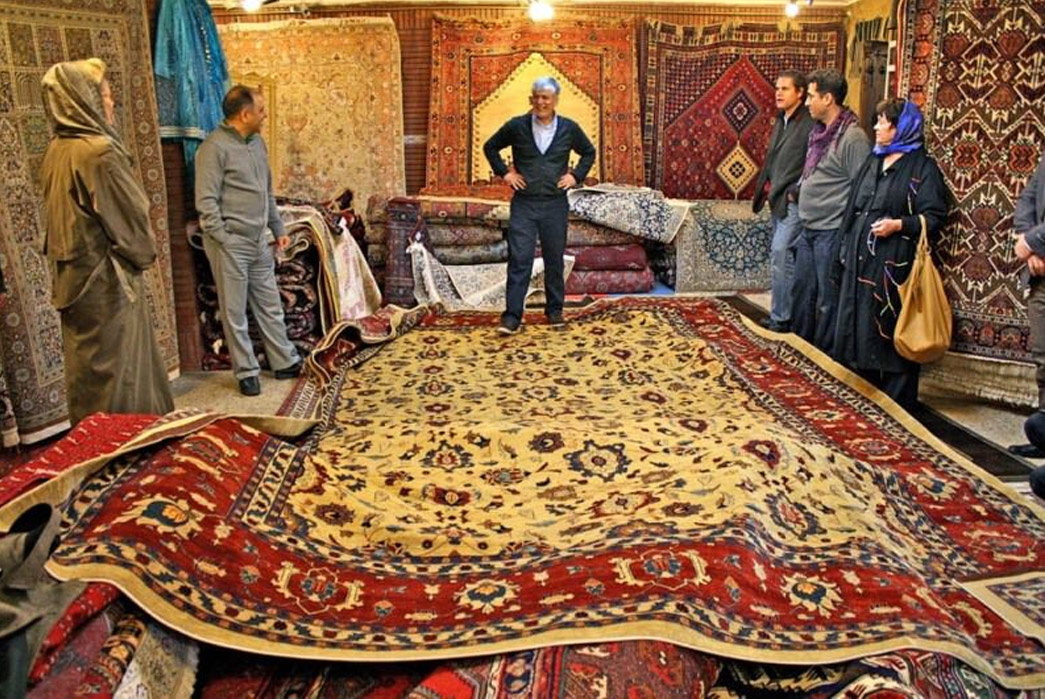 Persian-Rugs---History-&-Buyer's-Guide-An-Iranian-carpet-market-where-heritage-style-rugs-are-still-traded-today.-Image-via-Origian.